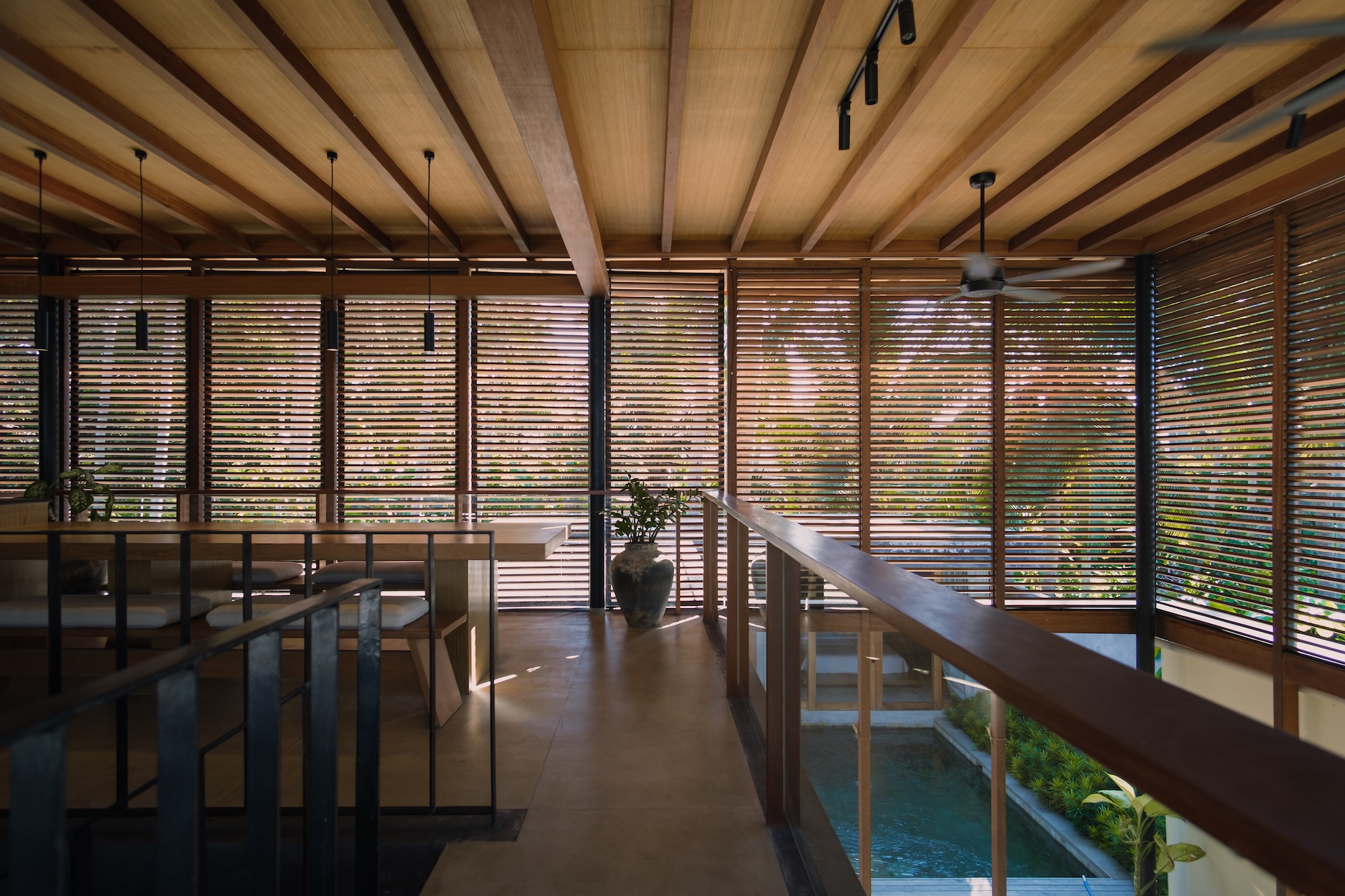 1st villa upper floor dining room space showing surrounding screens and void towards living room below