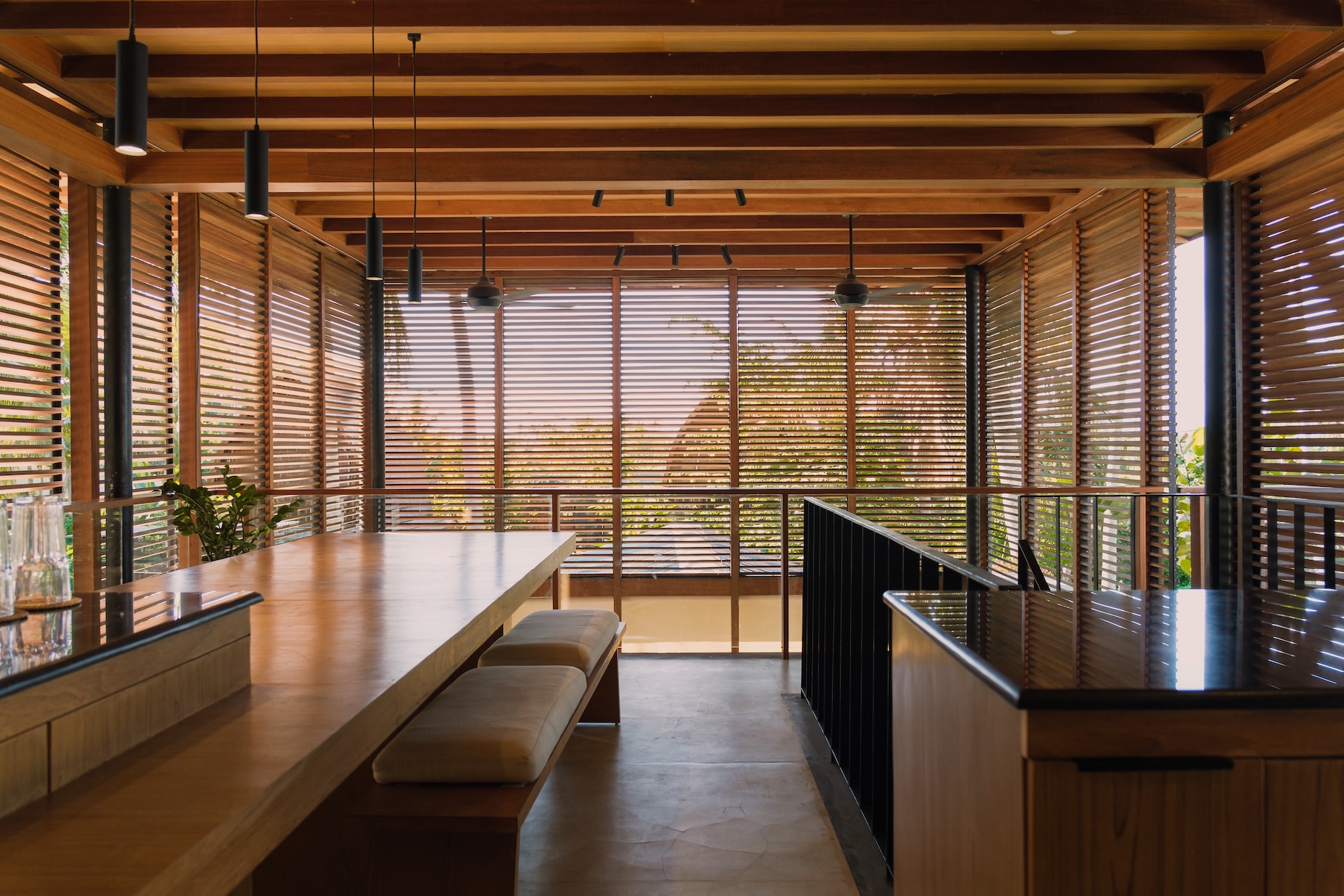 Upper floor dining and kitchen space at villa 1 showing surrounding screens and dining table