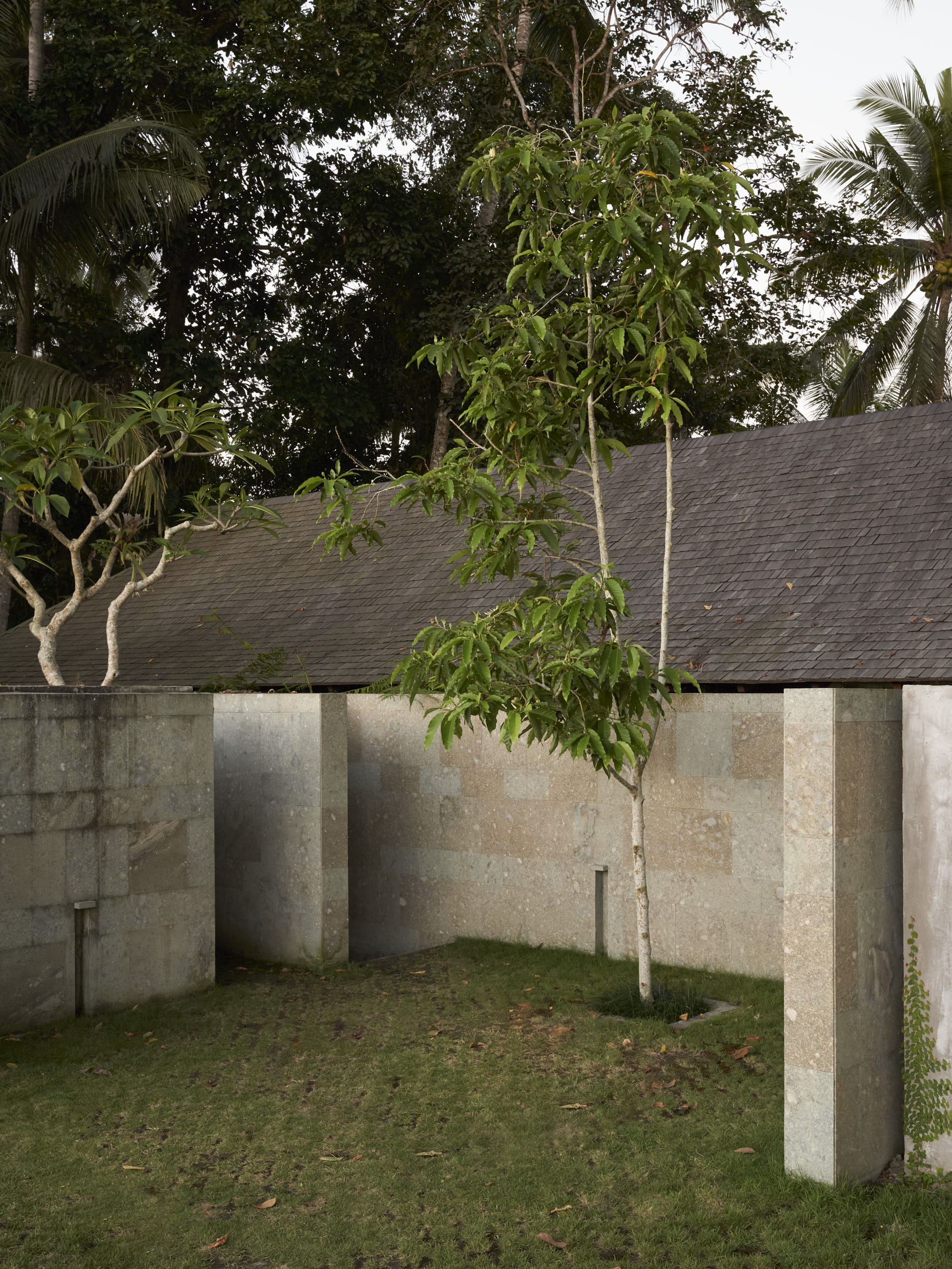 Arrival and parking space showing featured walls and the long roof of Rumah Haruku