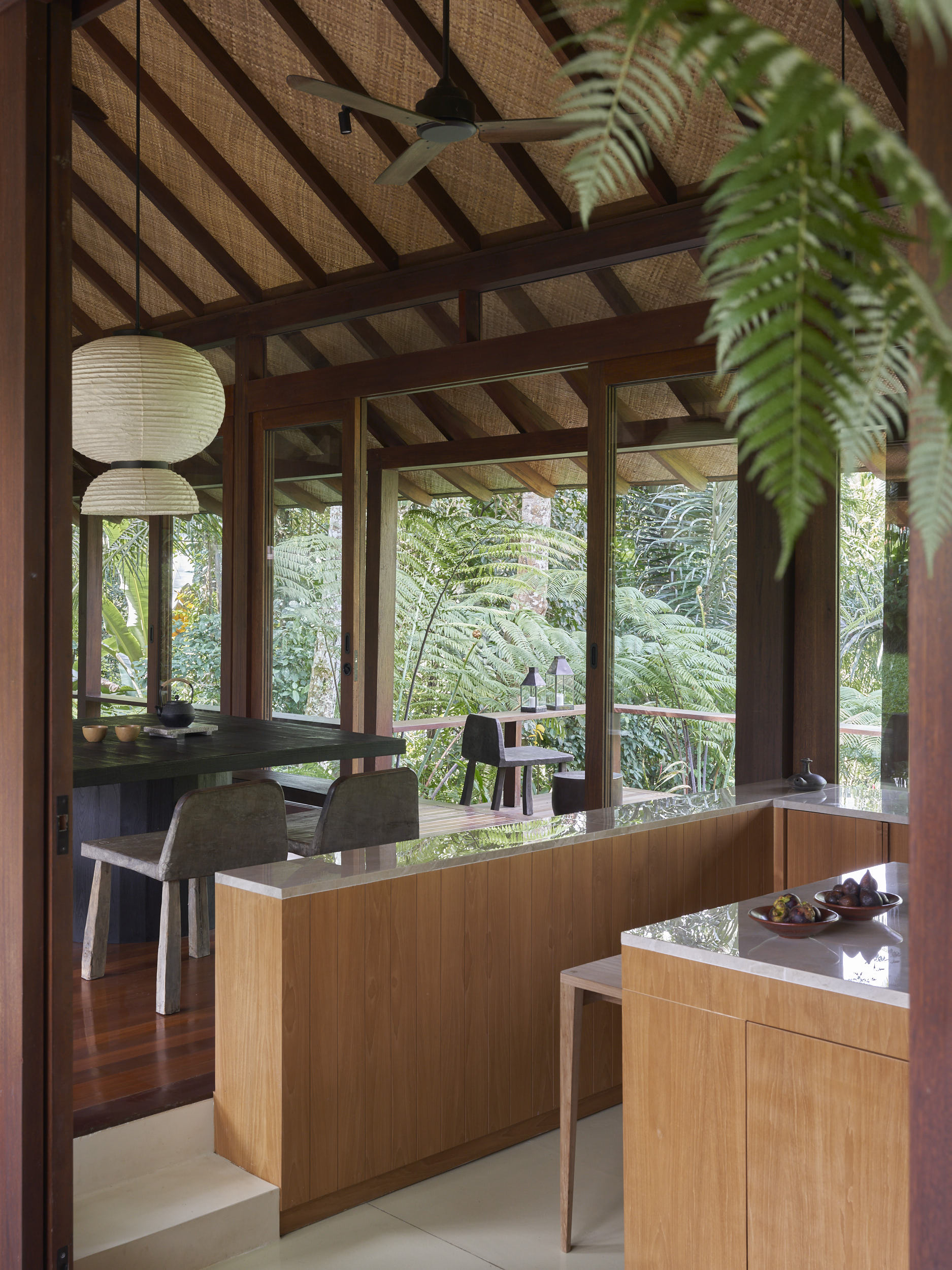 Side view of the kitchen stepping down from the dining room and opening towards the landscape