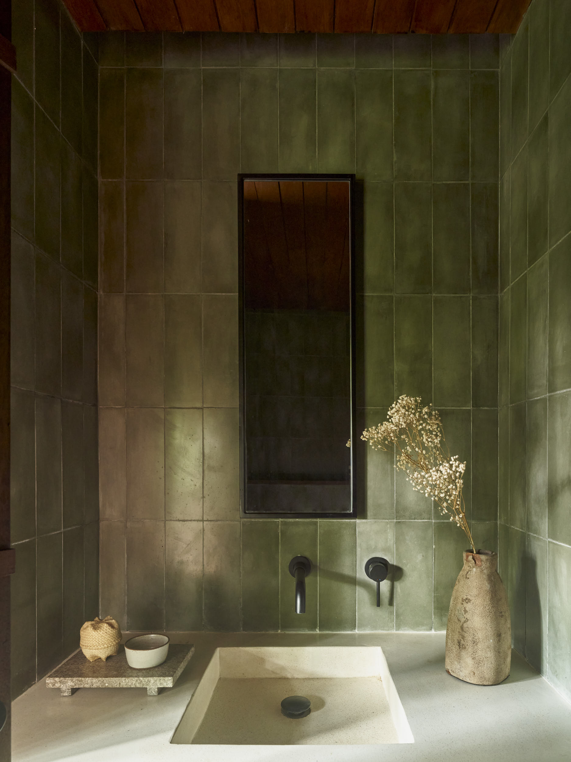 Powder room basin in green cement tiled space