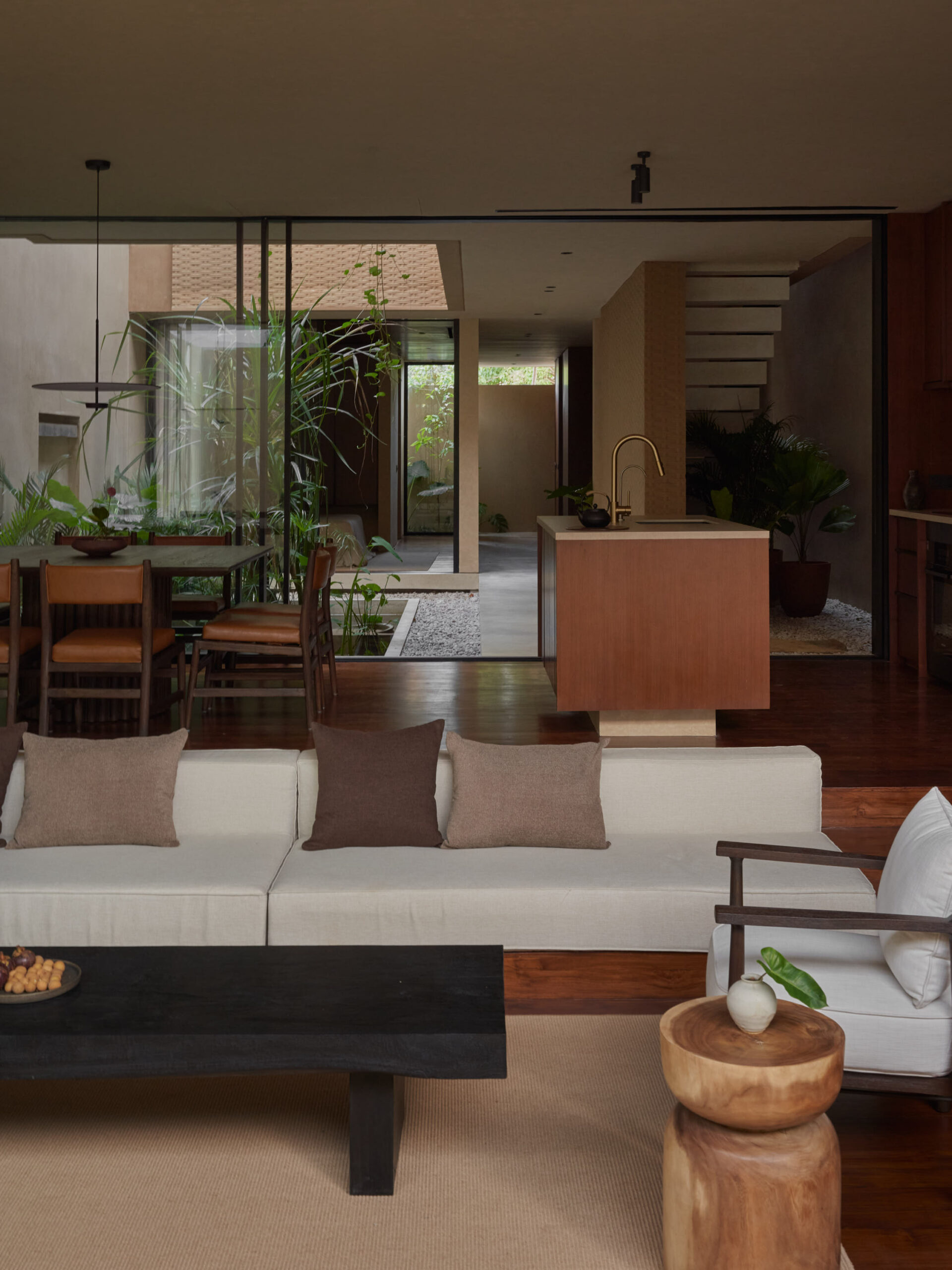 Vertical view from the living room showing the sunken sofa area, dining and kitchen space, and the inner courtyard