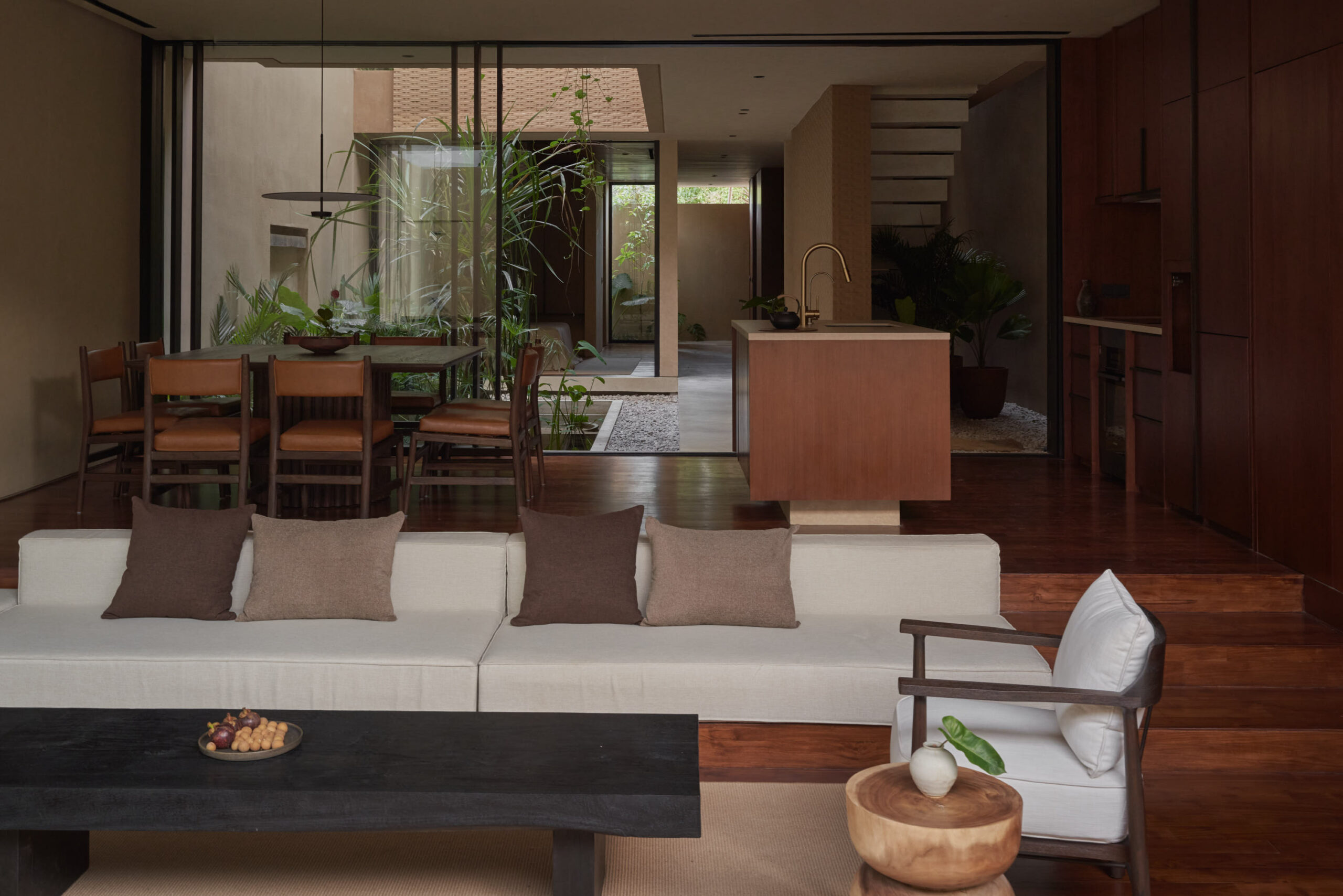 View from the living room showing the sunken sofa area, dining and kitchen space, and the inner courtyard