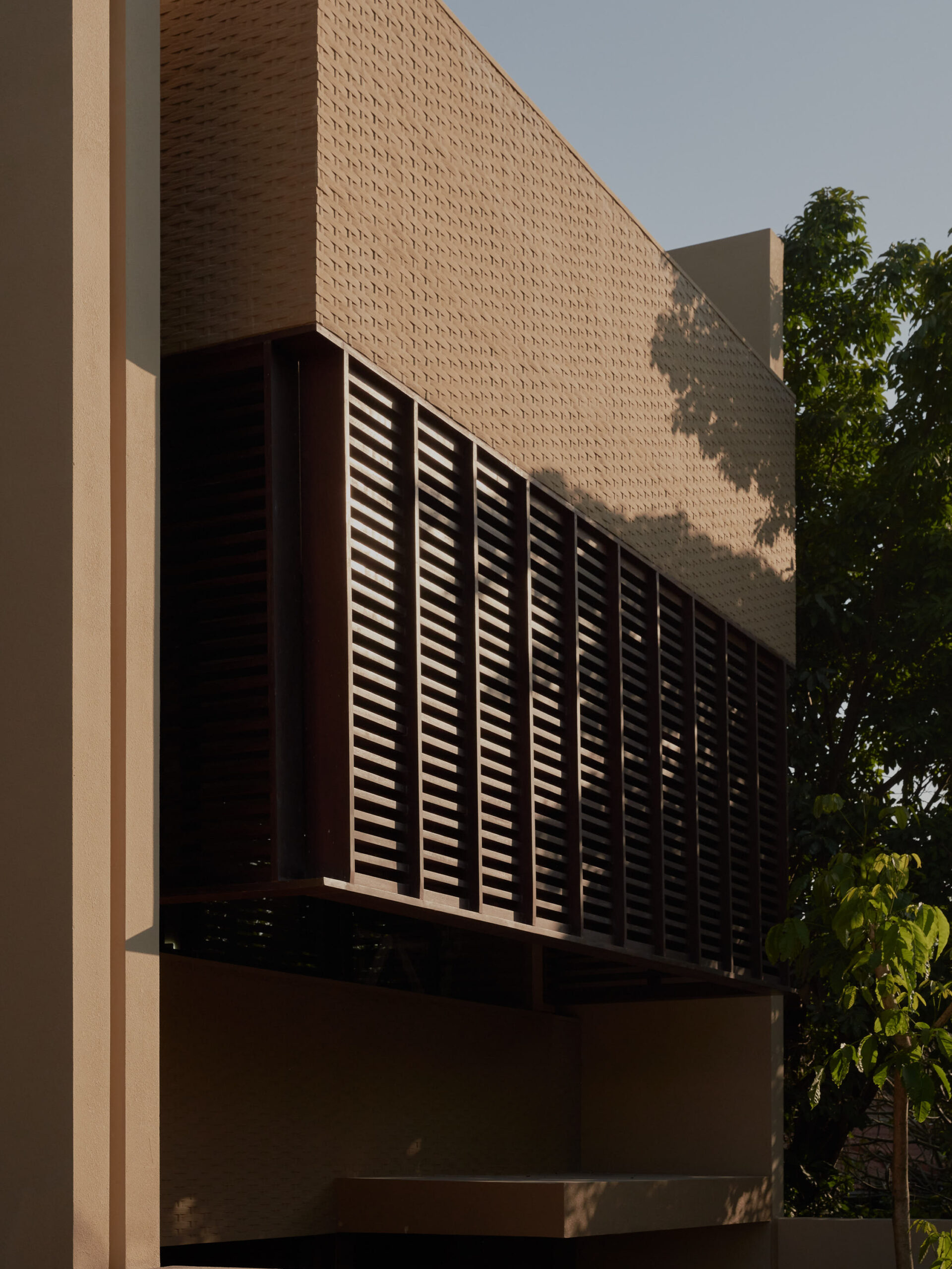 Close up facade showing wooden elements and bamboo pressed concrete feature wall