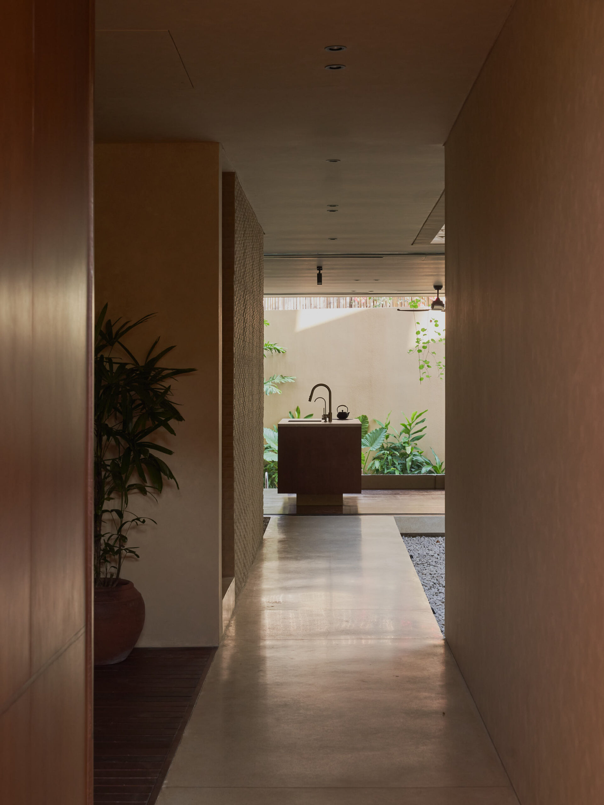 Arrival corridor at Leaf Berawa, continuous view from the entrance to the back of the house looking through the kitchen and living room