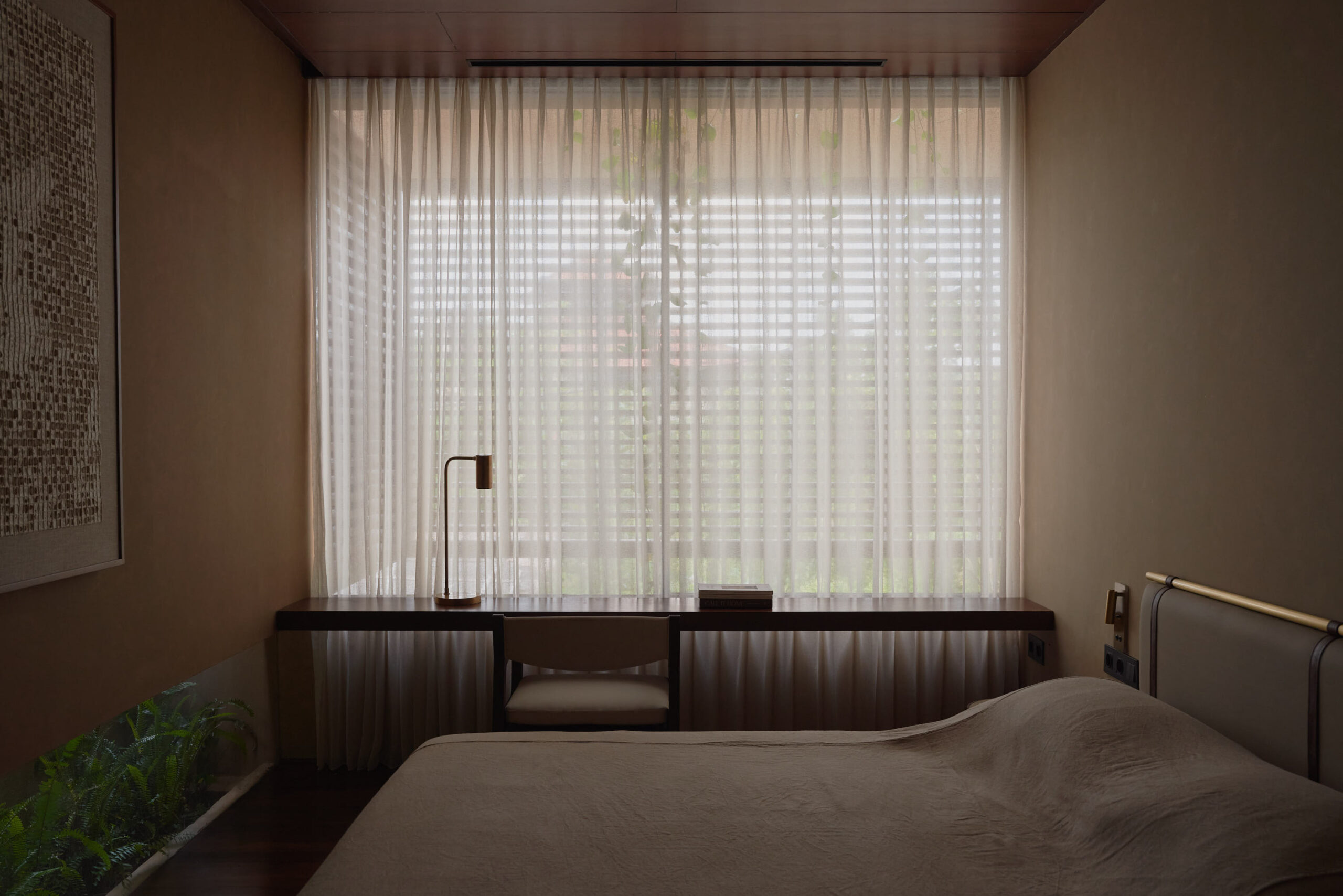 Master bedroom looking towards the window covered by sheer curtains