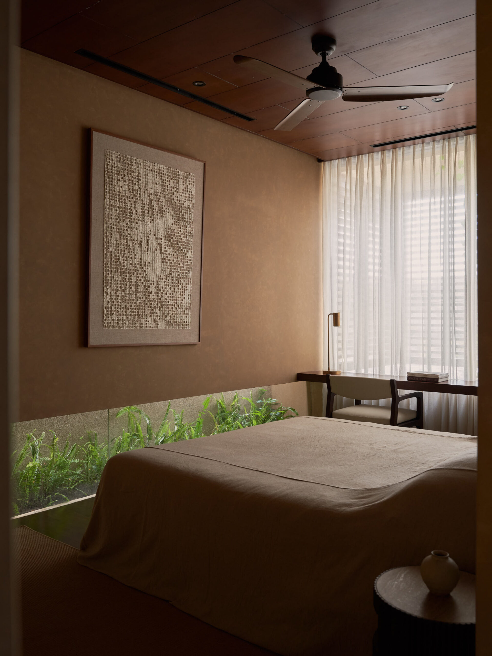 View of master bedroom with linen covered bed, banana paper art work, and floating desk towards the window