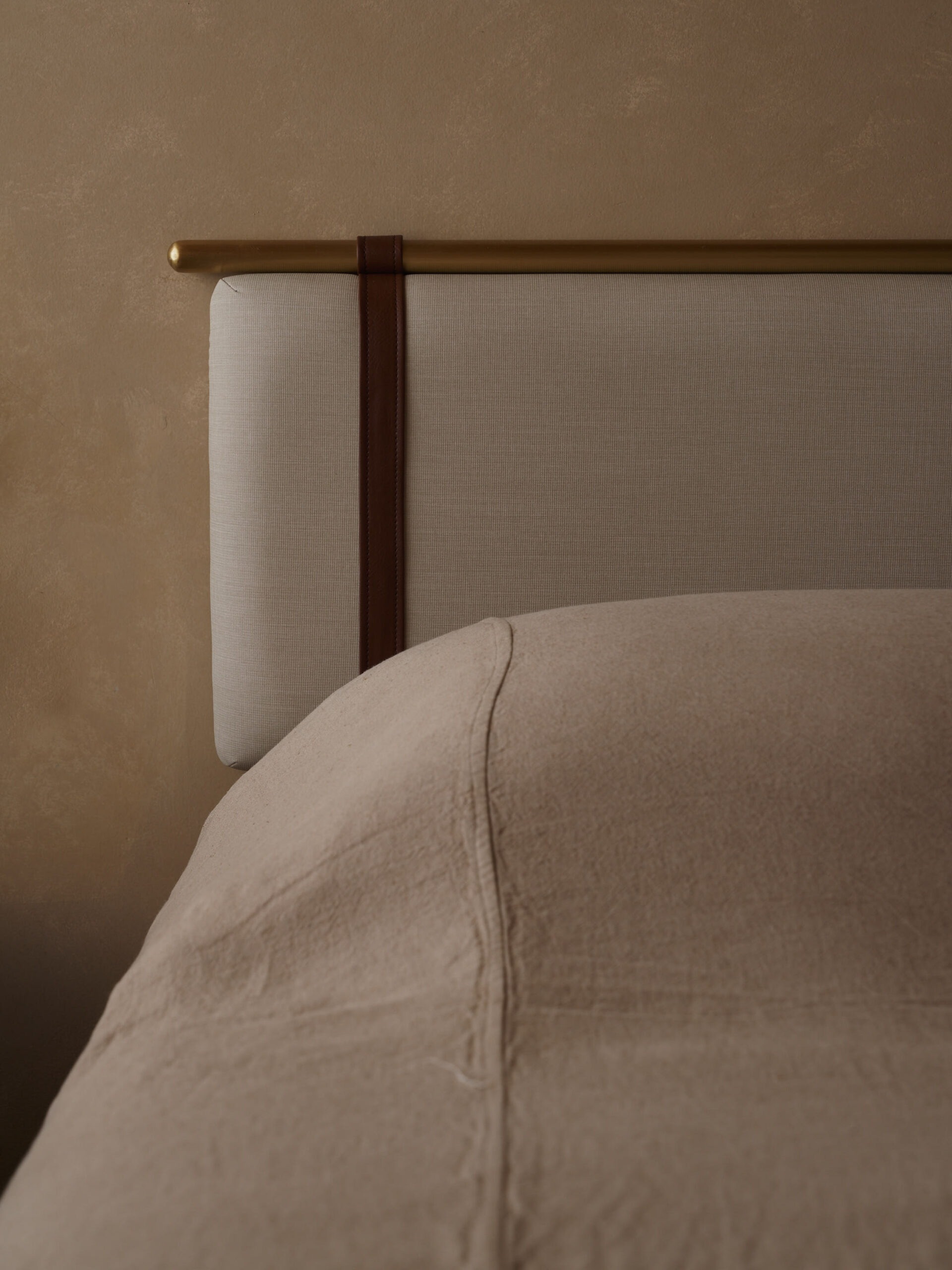 Detailed photo of the head board with leather and brushed gold accents