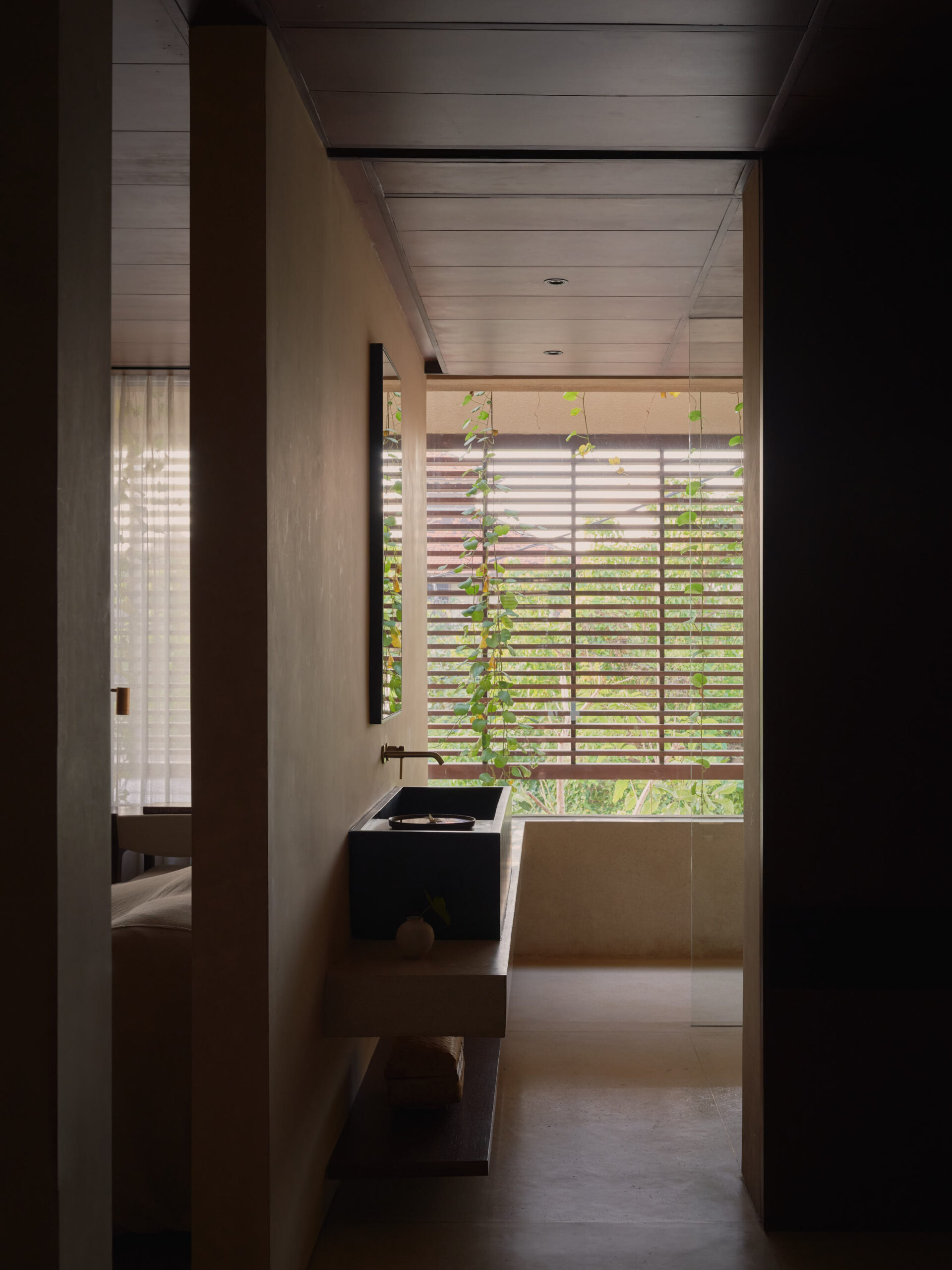 Vertical view of master bathroom with opening towards facade wooden screen