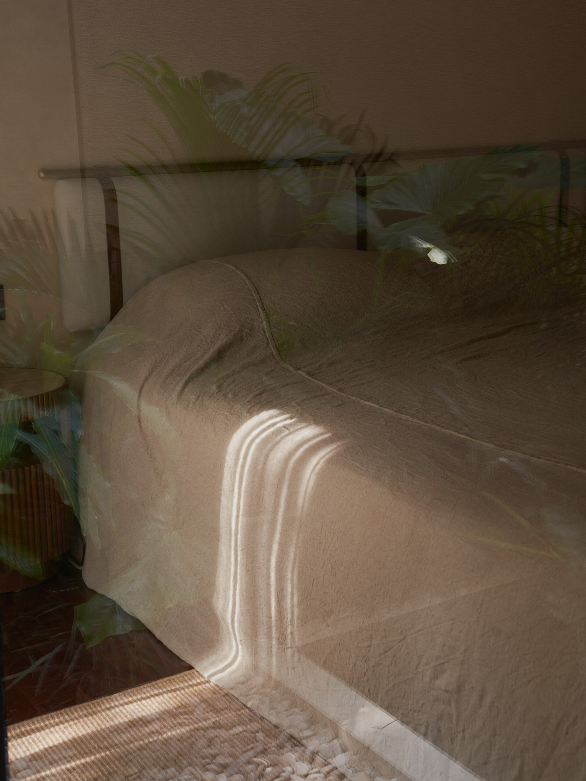 Detailed side view of the bed covered in natural linen fabric