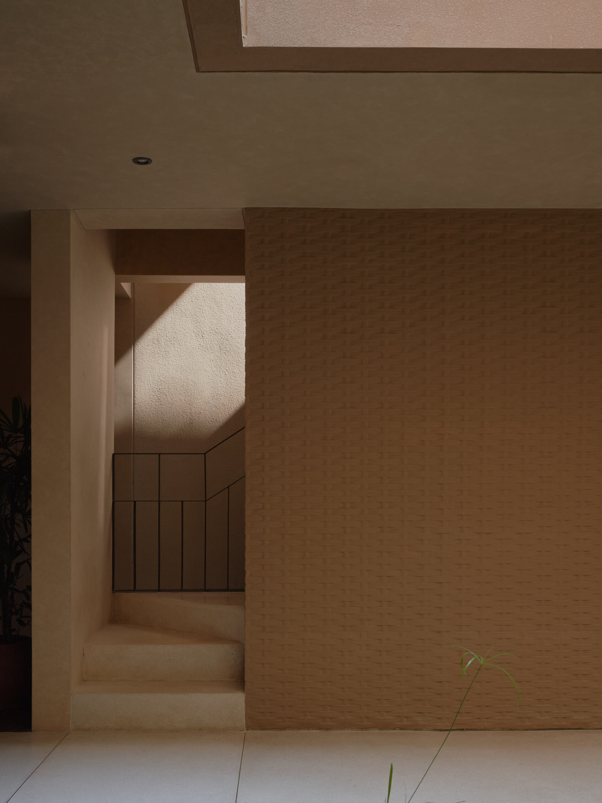 Detailed view of the staircase wrapped around the bamboo pressed concrete wall at leaf berawa