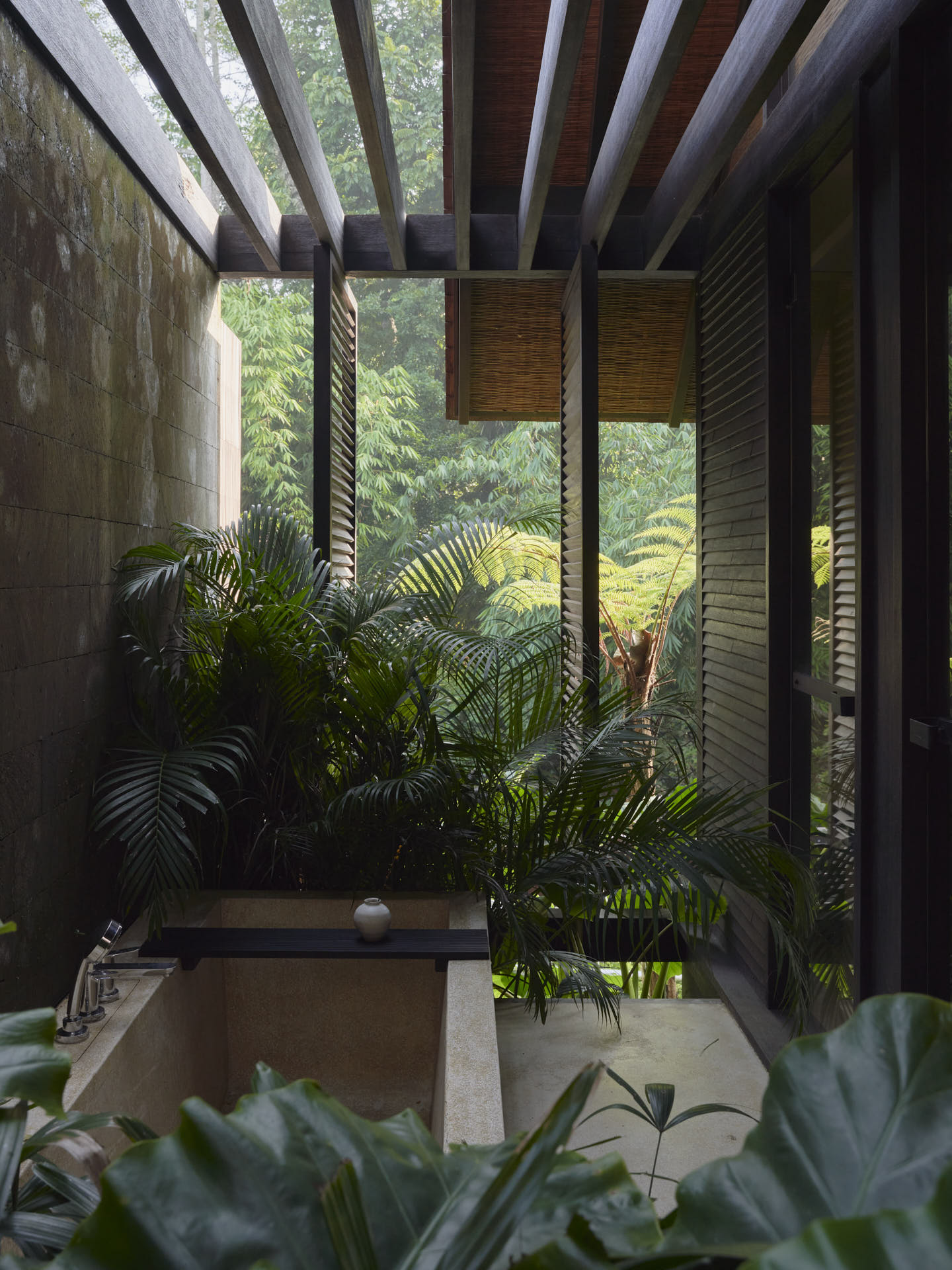 View of outdoor bathtub surrounded by plants