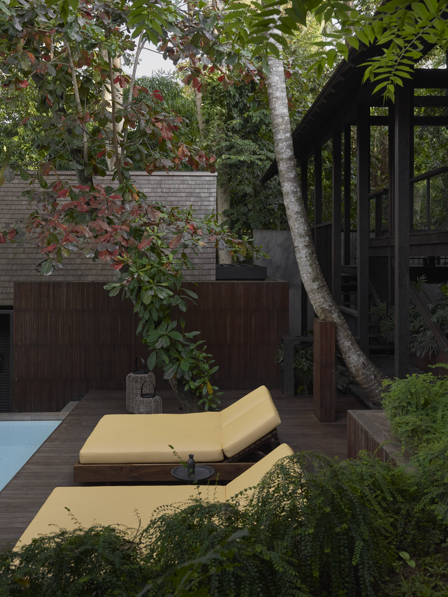 View looking over pool deck with main pavilion on the side and a bedroom pavilion in the front